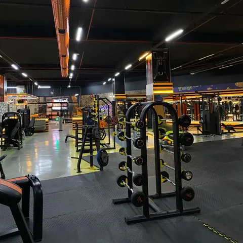 Barbell rafı ve arkasında uzanan makine bölümü